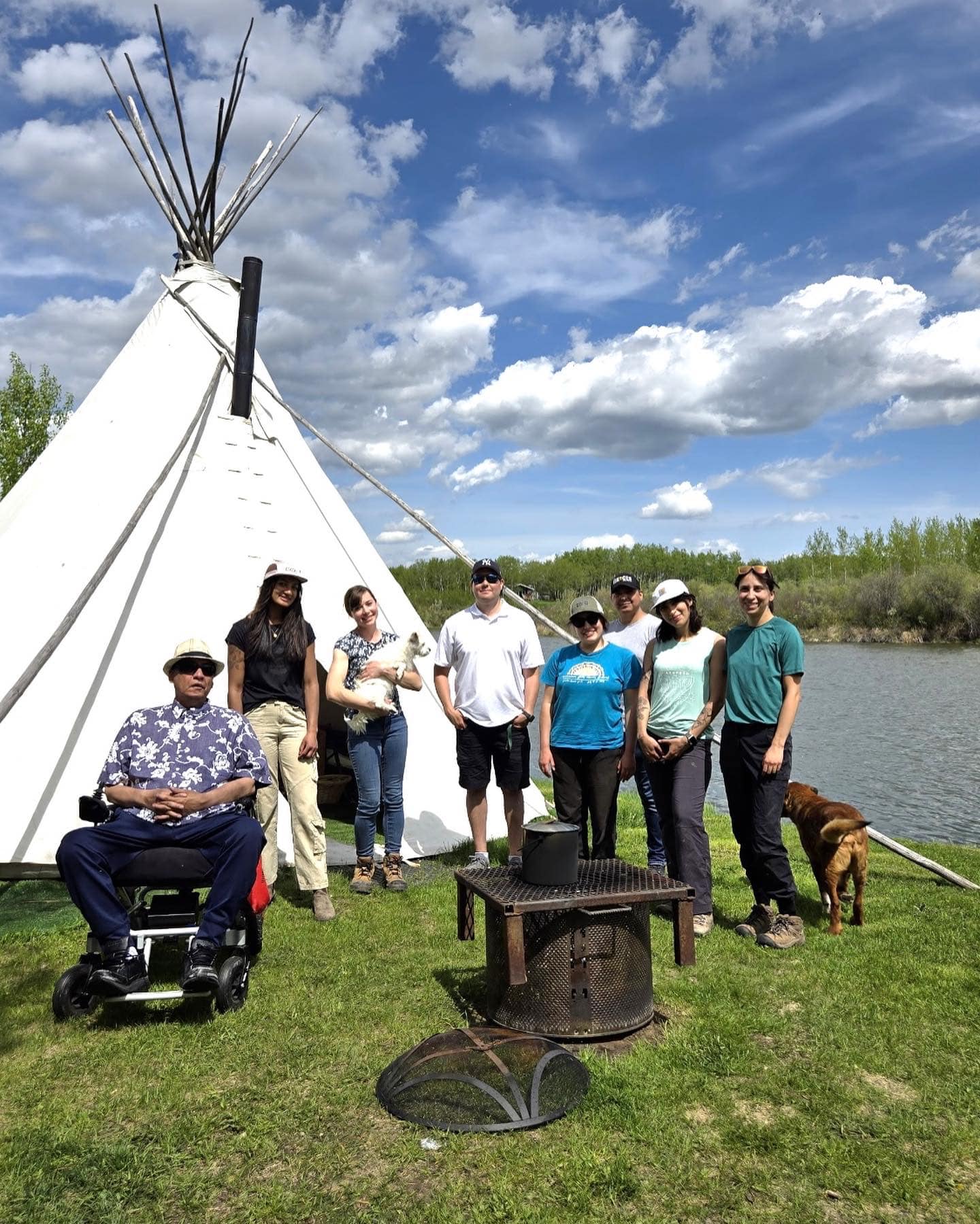 People standing in front of a teepee