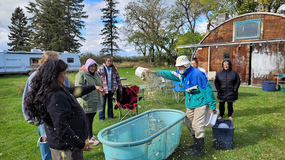 People winnowing seeds at Prairie Garden Seeds farm