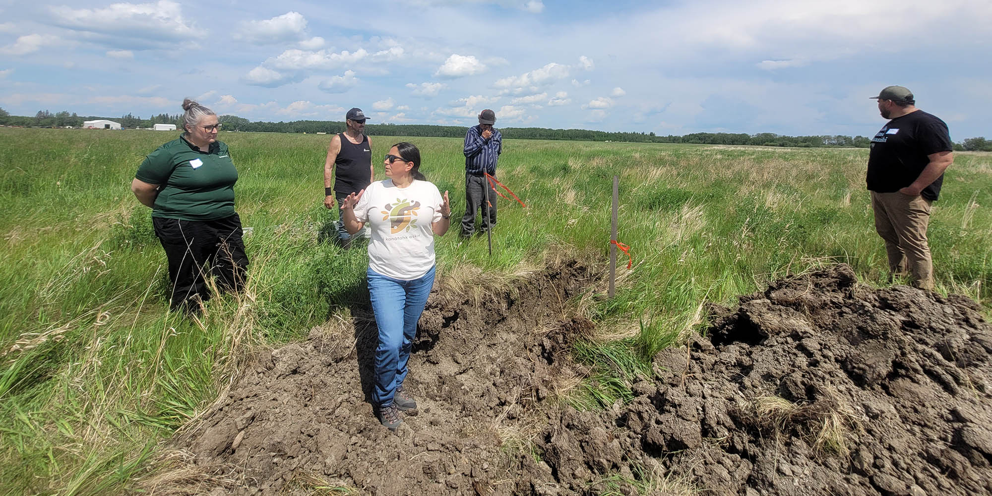 People outdoors learning about soil at Flying Dust First Nation